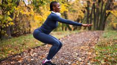 Woman in sportswear outside performing squat exercise