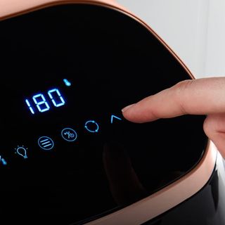 Persons finger changing the digital temperature dial on the Tower Vortex air fryer