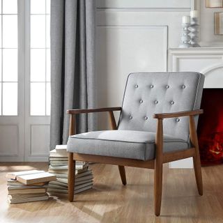 grey low accent chair with wooden details in a living room