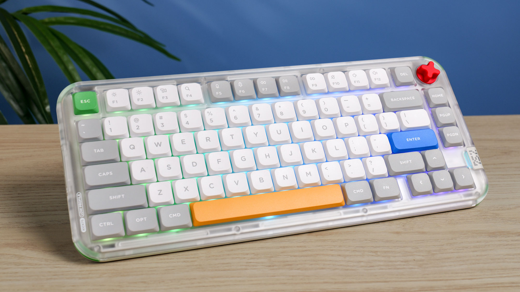 The NuPhy Kick75 on a wooden surface with a blue wall in the background