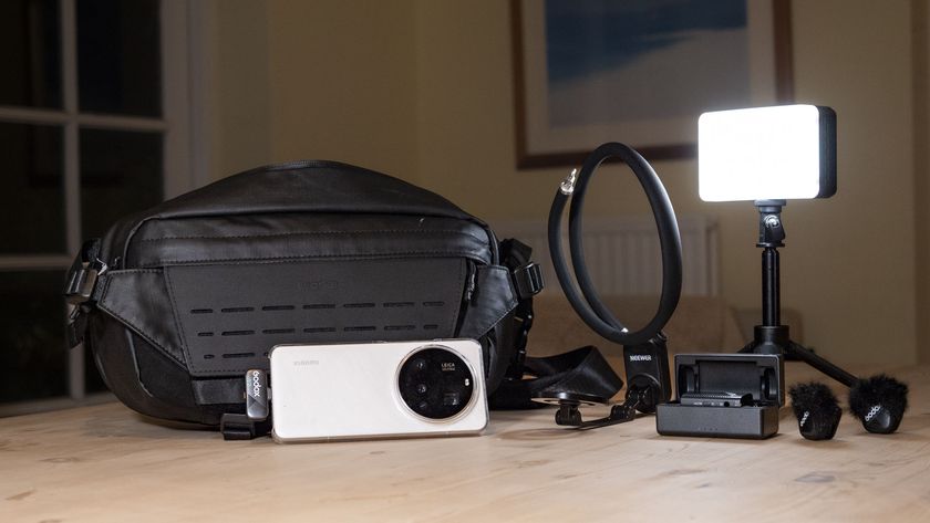 A collection of vlogging camera gear on a wooden table