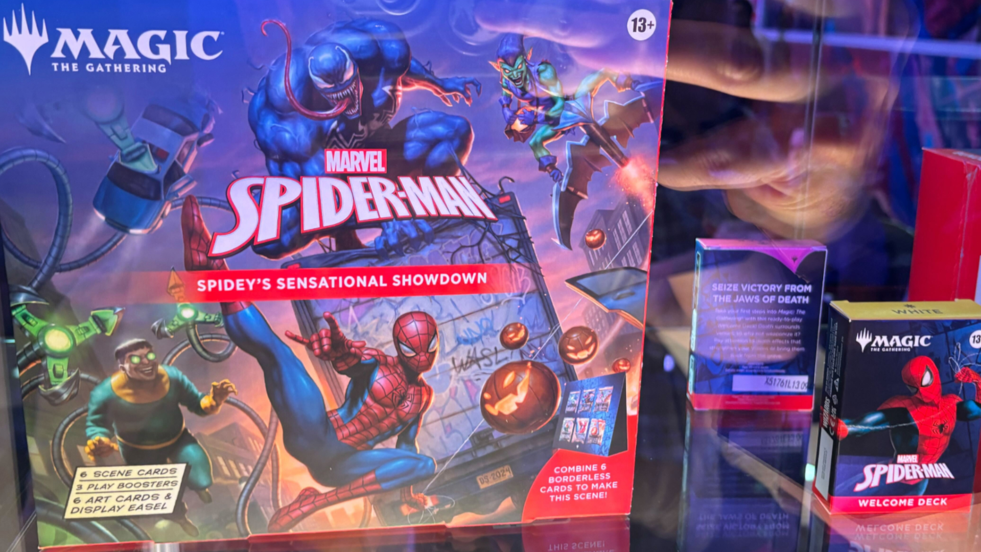 MTG Spider-Man boxes laid out in a glass case