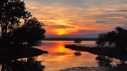 Spring Bay, Illinois, USA. Sun sinks into a colorful sunset above the Illinois River.