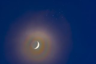 moon shines next to the Pleiades stars in the night sky.