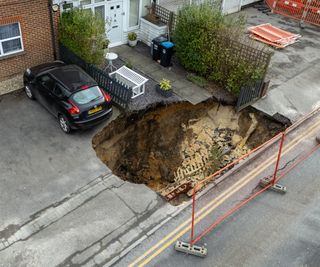 A sinkhole on a driveway outside a house in Surrey