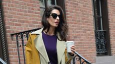 Amal Clooney wearig a yellow coat and purple dress