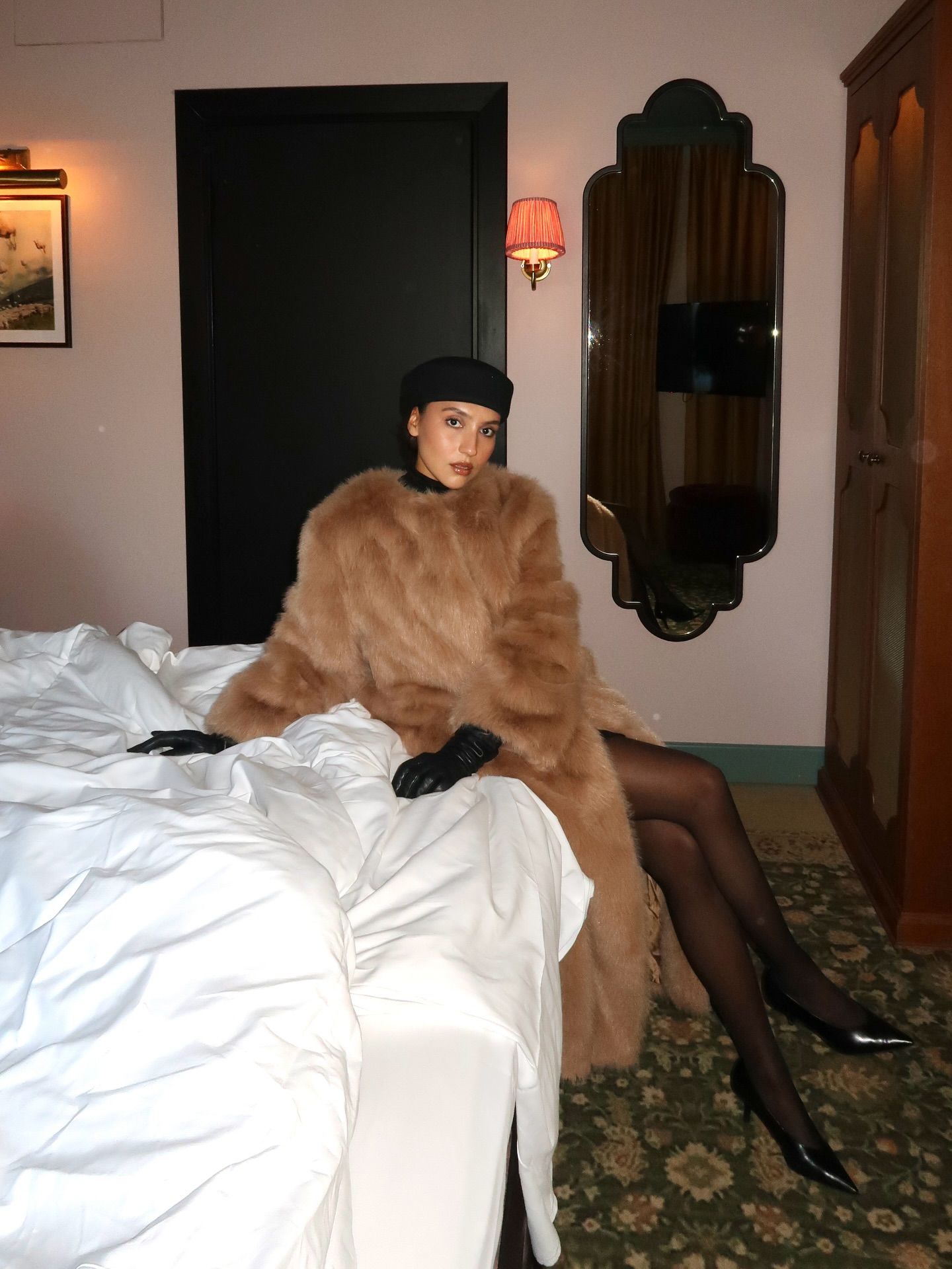 Street style photo of woman wearing a long fur coat.
