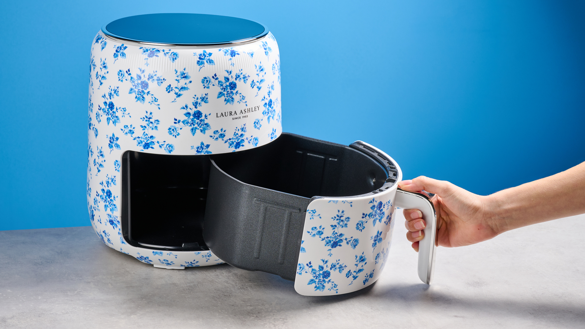 the Laura Ashley Air Fryer in blue and white floral print, showing the air fryer basket and black touchscreen on the top