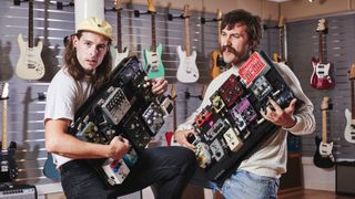 Two guitarists from IDLES with their pedalboards