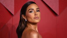 Close up of Olivia Culpo with a red background.