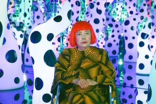 Artist Yayoi Kusama in front of colorful objects