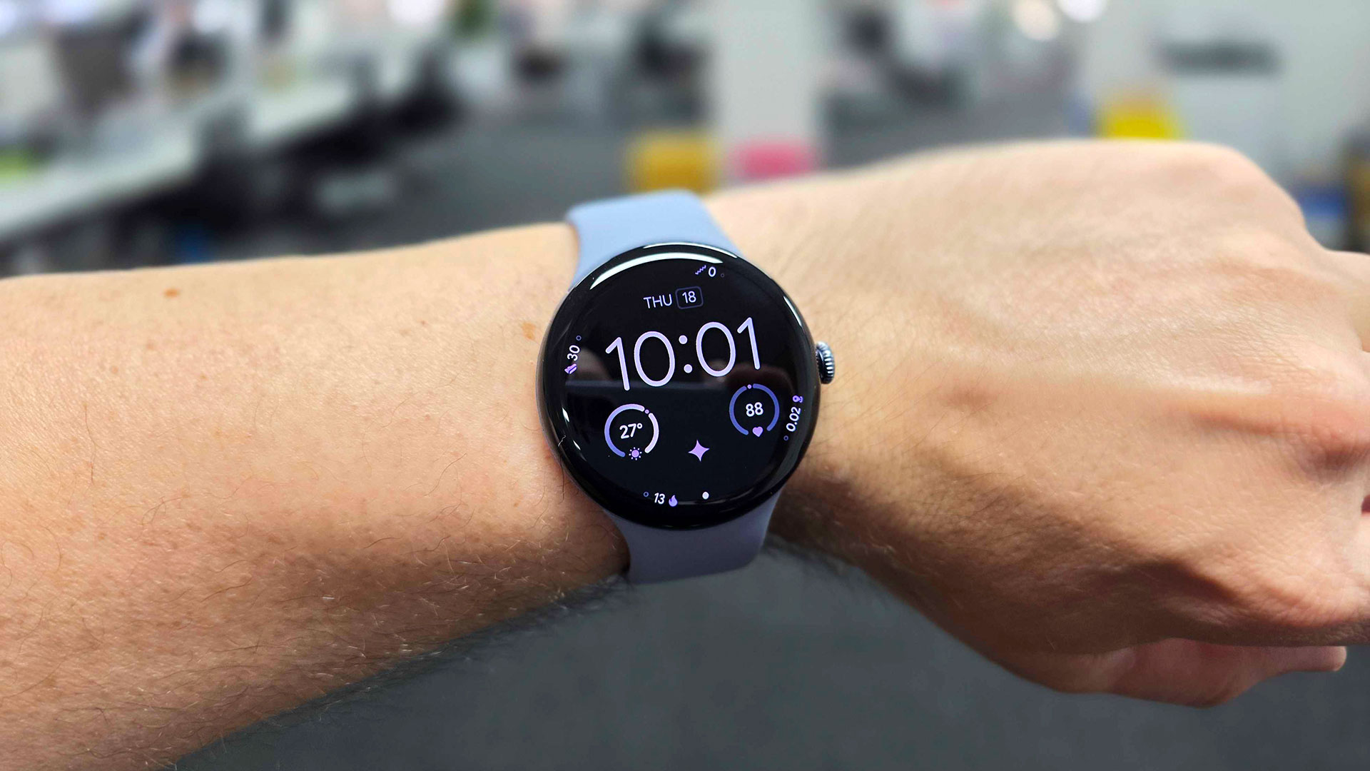 Pixel Watch 4 on wrist showing time, weather and heart rate.