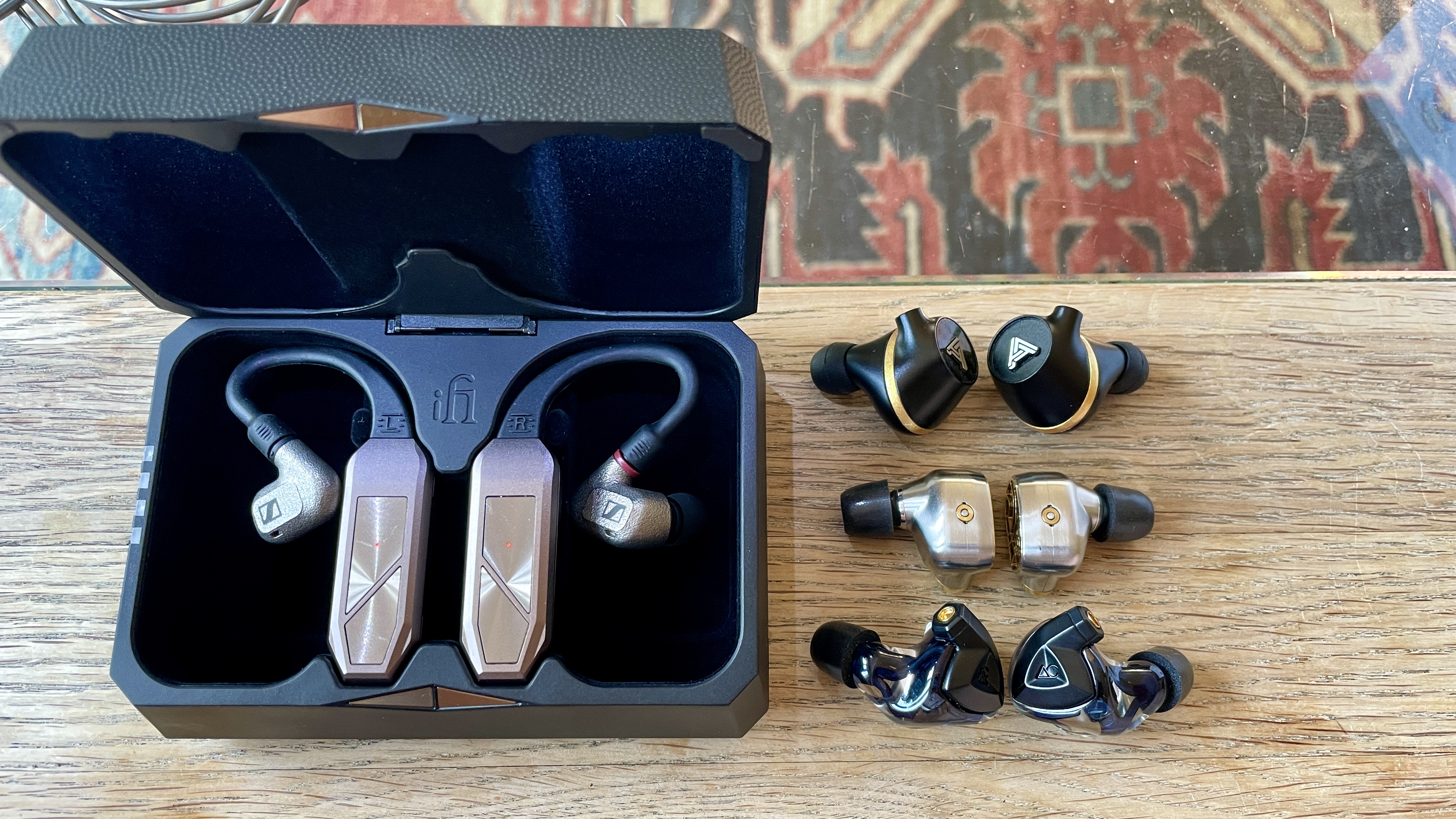 iFi Go Pod in a hand, with high-end wired earbuds and in the case, which accepts even larger earbuds