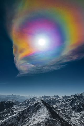 During the Spring Festival, the Sun and altostratus clouds acted together to create this huge corona, soaring above the Himalayas. The result is an enormous colour palette above the snowy peaks