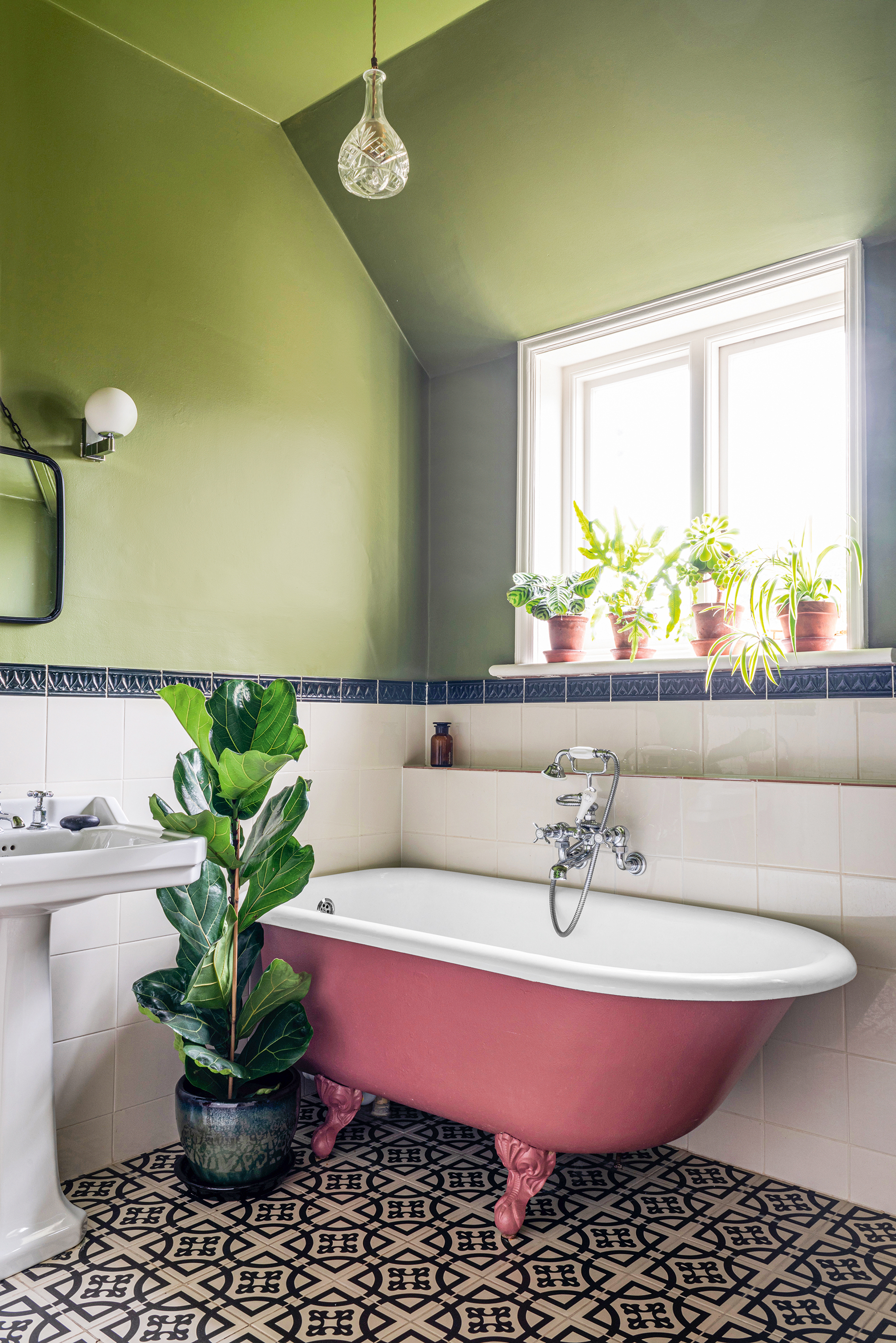 Green bathroom with white tiles and pink bath