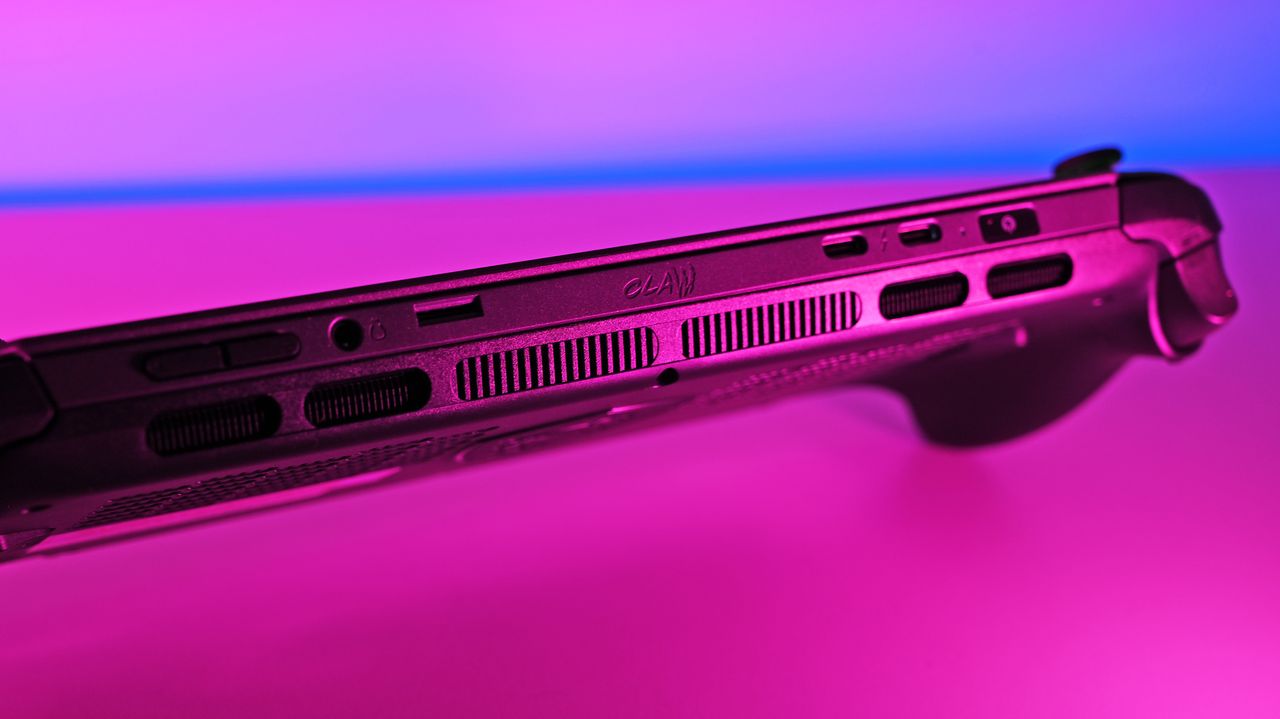 A dramatic, angled view of the console's top edge under pink lighting, focusing on the centered "Claw" text logo engraved above the main cooling vents.