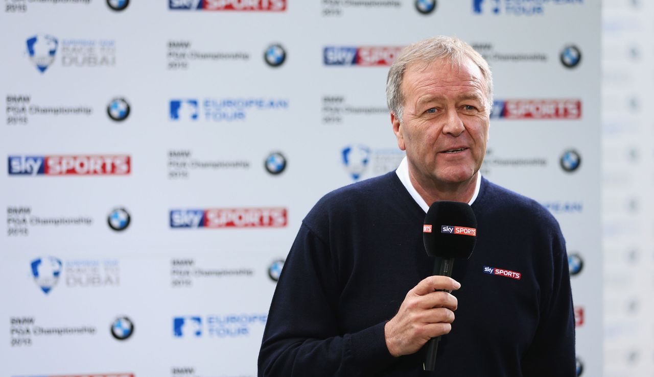 Murray holds a microphone in front of a banner