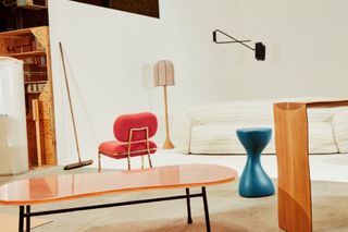 Furniture from the newly launched Pierre Yovanovitch Mobilier label including white sofa, pink upholstered chair, glass table, floor lamp and blue stool