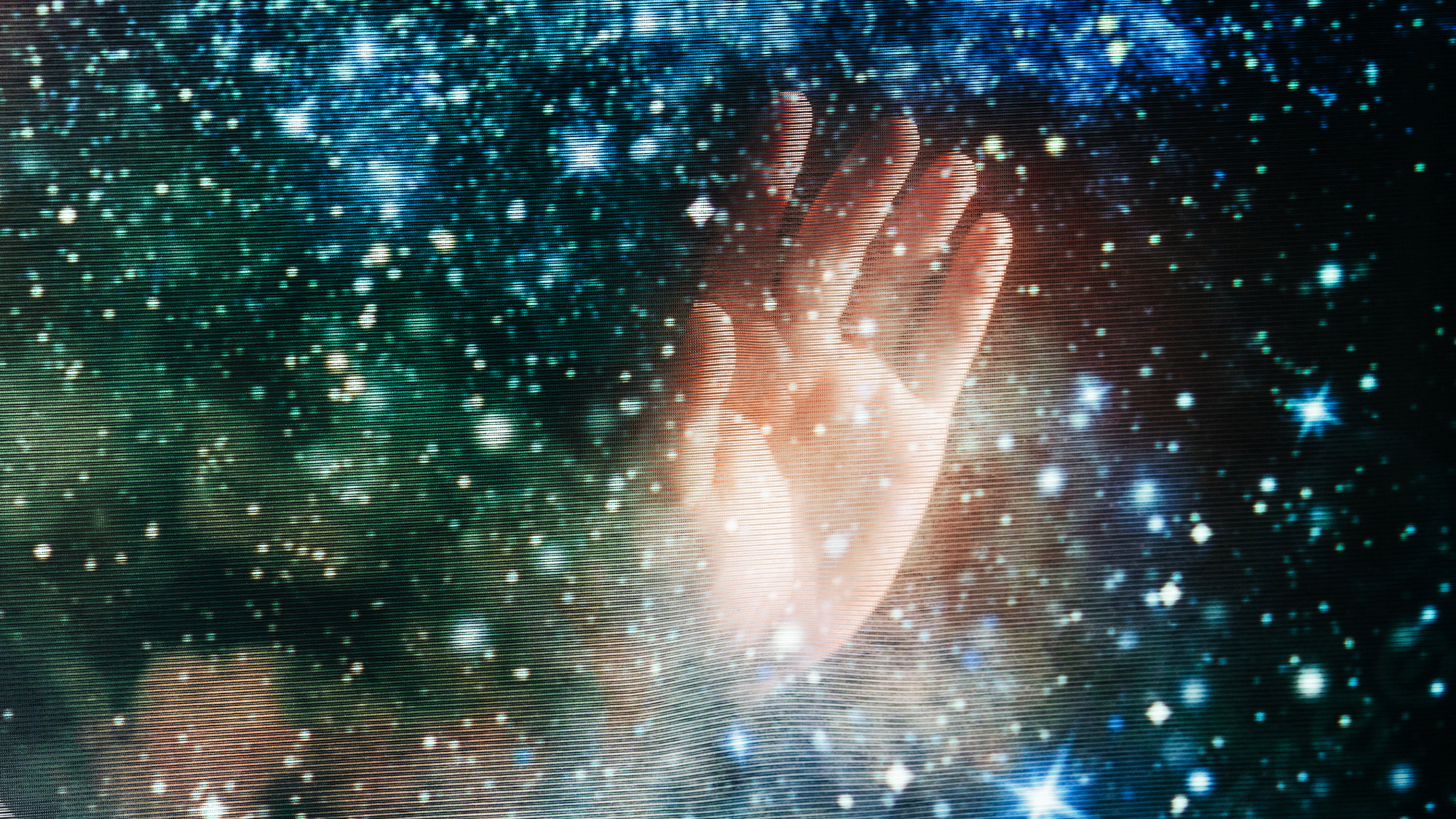 A picture of someone's hand overlaid with a translucent deep space image