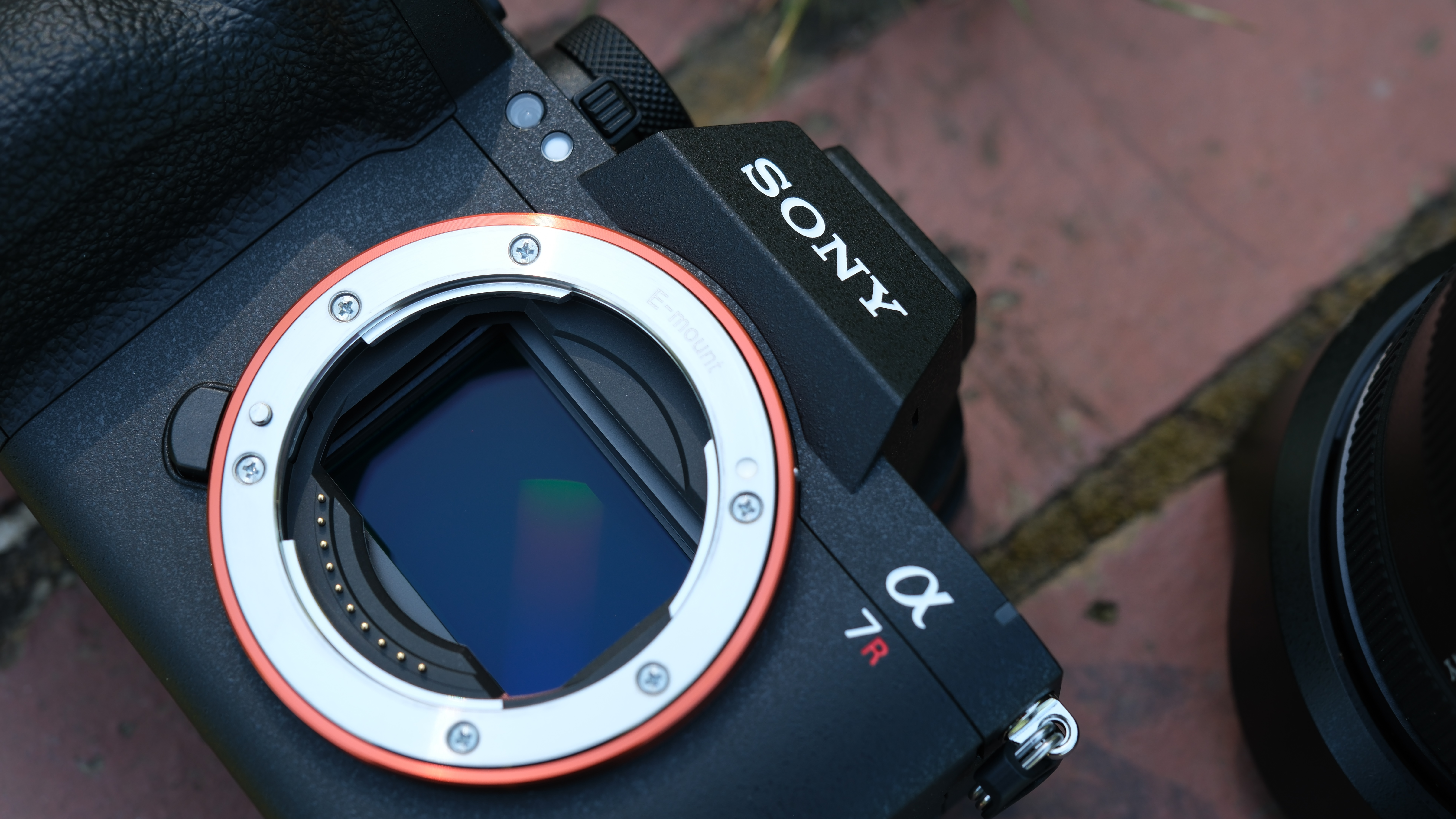 Close-up of the Sony A7R VI lens mount and full-frame sensor on brick paving.