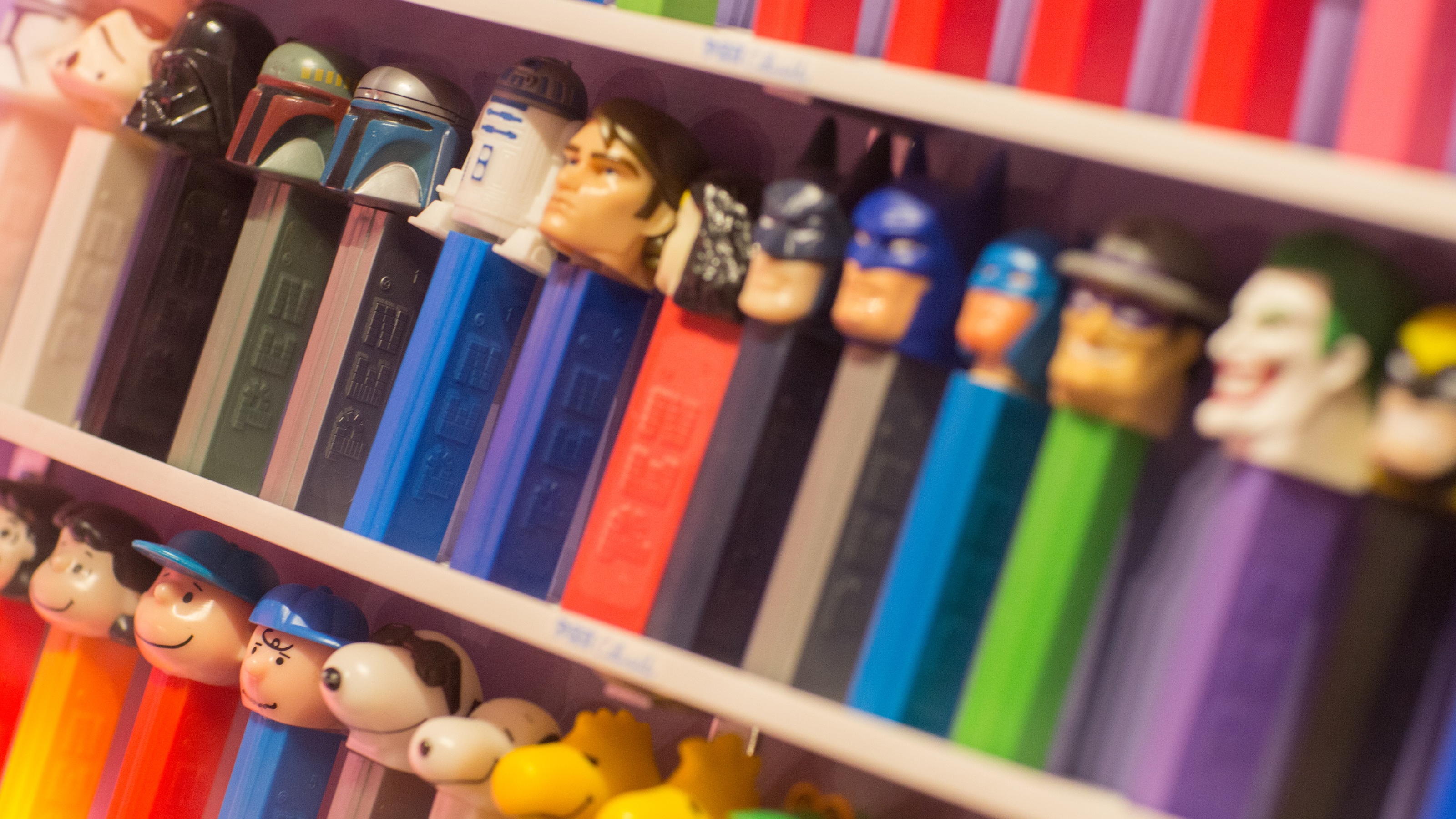 Pez dispensers lined up on a collectors&#039; shelf.