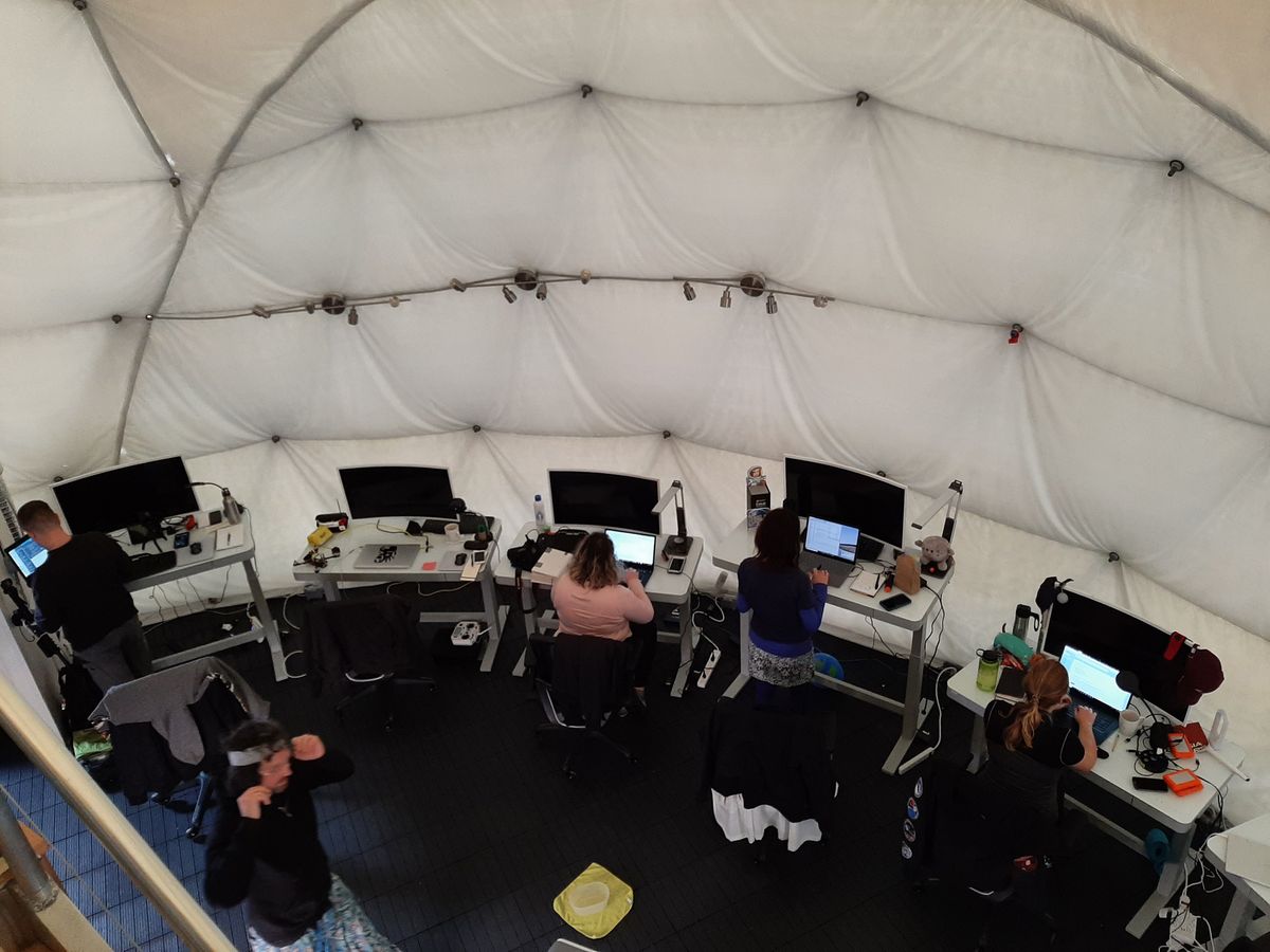 Selene IV crewmembers focus on their research projects at their workstations in the HI-SEAS habitat.