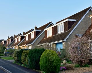 Row of modern English detached houses with double dormer windows