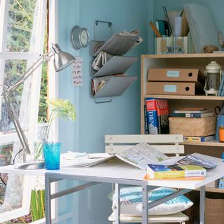 garden shed with blue walls and wooden shelf