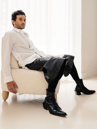 Portrait of Tariq Dixon sitting on a white chair