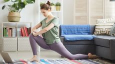 woman at home on yoga mat doing a hip flexor stretch
