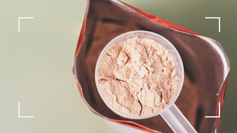 Open bag of protein powder for weight loss with scoop on light green background