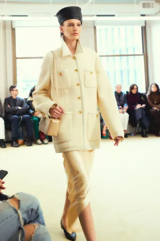 Altuzarra model walks the runway in a cream cardigan and silk skirt