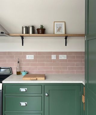 Pink and green kitchen with wooden shelving with black brackets