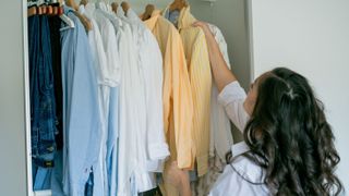 Woman organizing shirts in closet