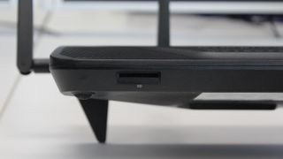 An SD card reader is located on the front edge of the router.