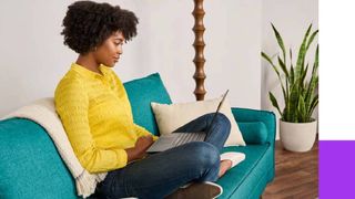 Woman sitting on a sofa working on a laptop