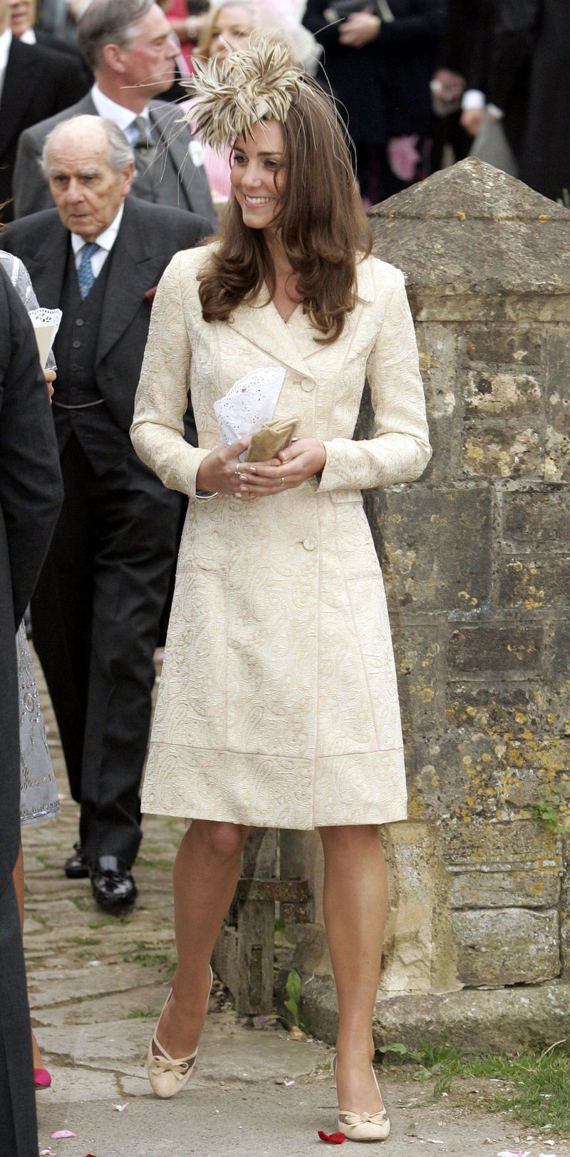 As Prince William's date to a wedding in Wiltshire, she dons an ivory coat dress by Jane Troughton with a matching fascinator.