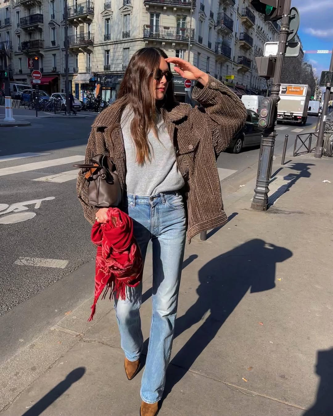 French woman wearing Western boots with jeans and brown jacket.