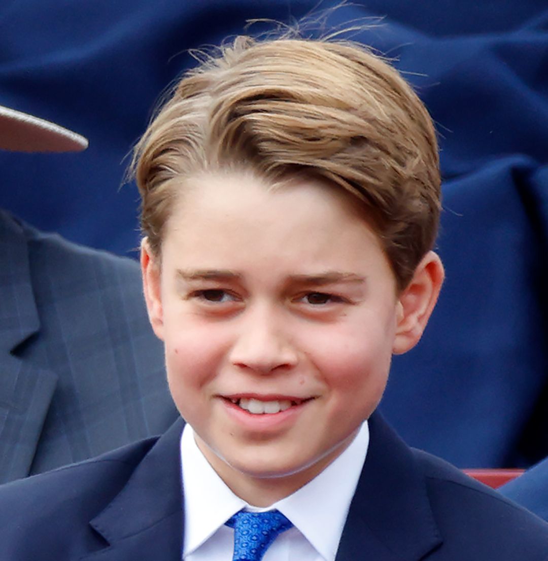 Prince George wearing a blue suit and smiling