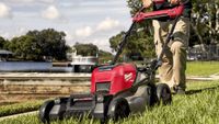 lawn mower deals | Man using Milwaukee M18 FUEL electric lawn mower