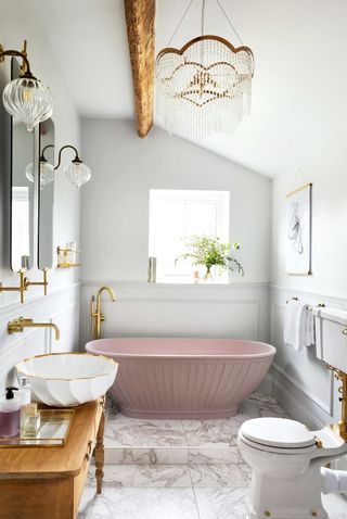 traditional bathroom ideas - pink bath in traditional bathroom with marble tiles and white saintaryware