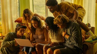 (l-r) Chase Stokes as John B, Madelyn Cline as Sarah Cameron, Madison Bailey as Kiara, Carlacia Grant as Cleo, Jonathan Daviss as Pope, Rudy Pankow as JJ, crowded around a laptop, in episode 401 of Outer Banks.