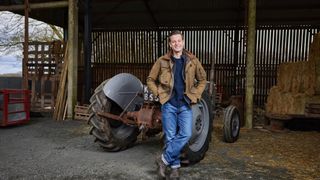 Matt Baker standing in front of a tractor for Our Dream Farm with Matt Baker