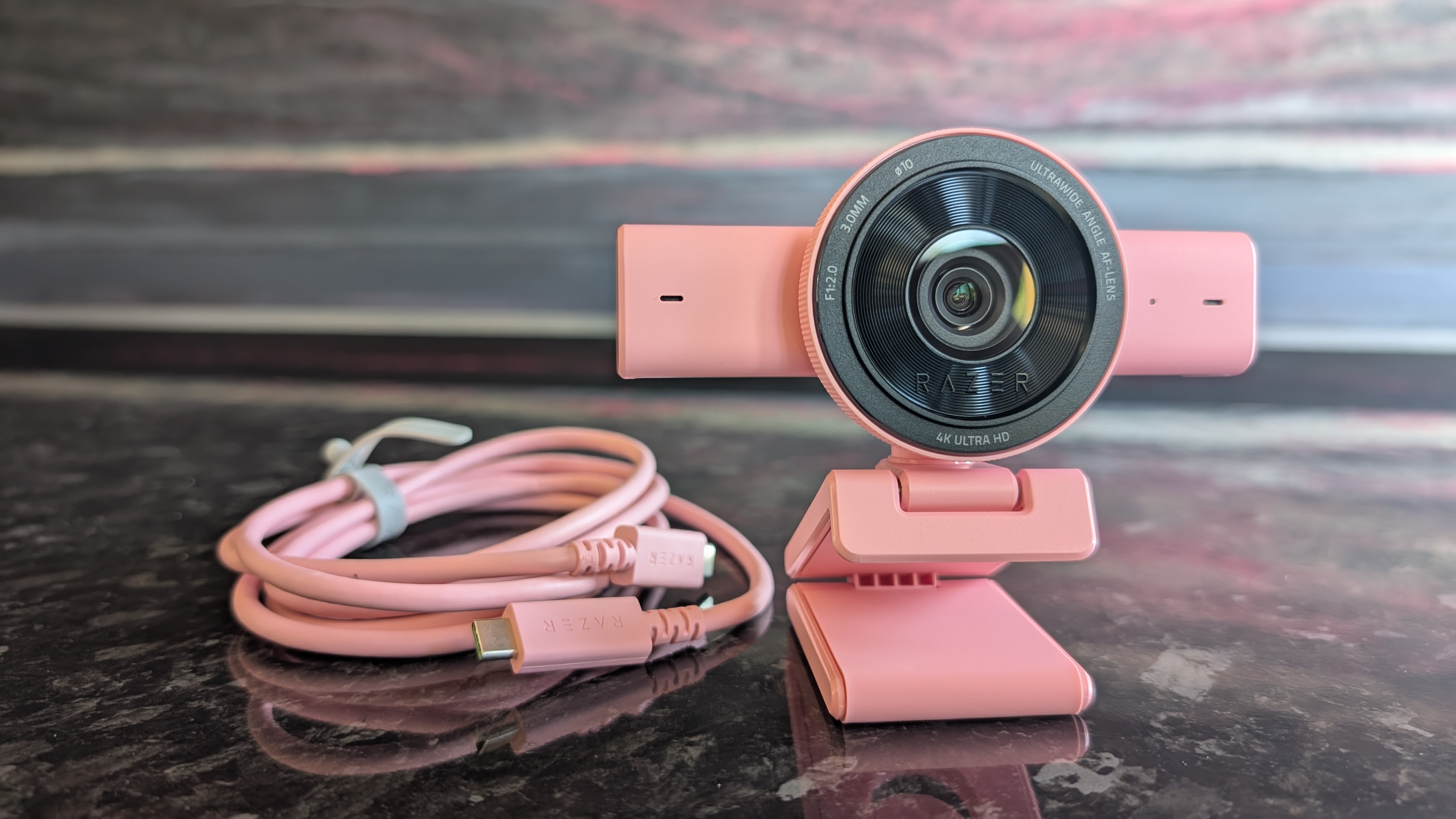 The Razer Kiyo V2 webcam pictured on a dark marble worksurface.