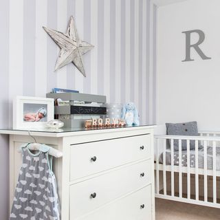 white nursery with striped feature wall