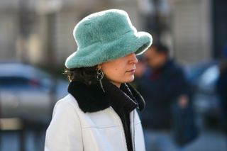 woman wearing fuzzy bucket hat and white coat
