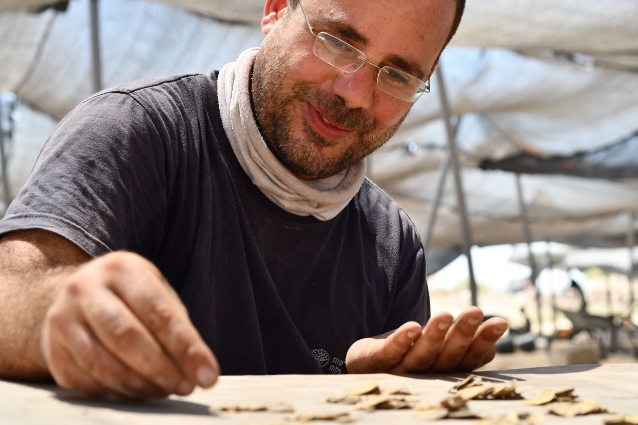 Shahar Krispin examines and counts the coins.