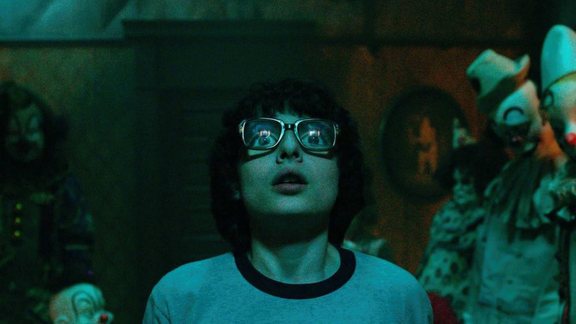 Finn Wolfhard as Richie Tozier in a room full of clowns in IT: Chapter One