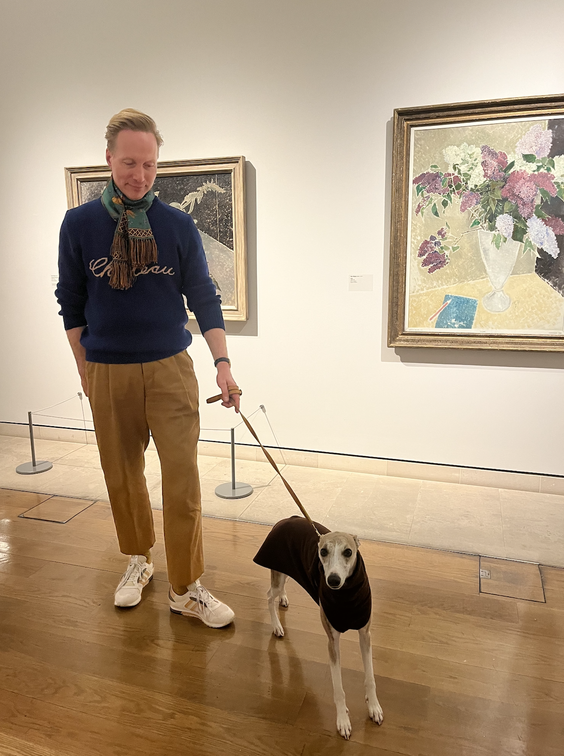 A man and a dog at an art gallery