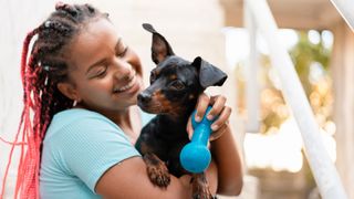 Woman holding puppy and dog toy